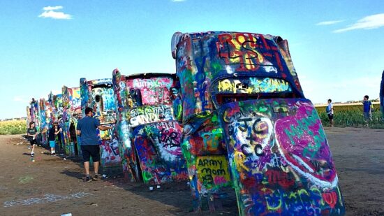 Tail fins of spray painted Cadillacs sticking out of the ground at the Cadillac Ranch in Texas