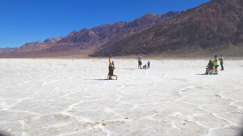 A woman is doing handstands on the salt flats of Badwater Basin