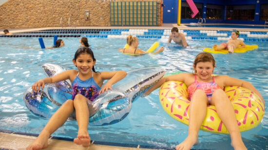 Two young girls floating on tubes at the Schaumburg Water Works one of the best indoor water parks in Illinois