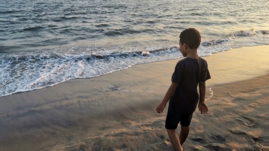 young boy at sunset on a Boston area beach