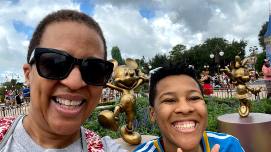 Black mother and college age daughter smiling at Disney World
