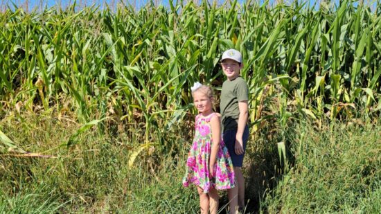 Kids standing in a corn field in Manhattan Kansas